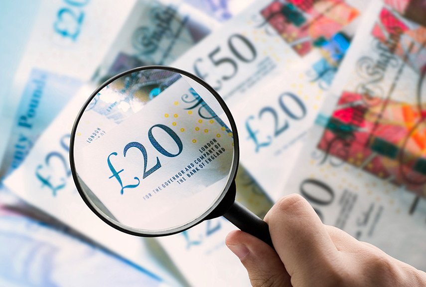 hand-with-magnifying-glass-on-20-pound-note