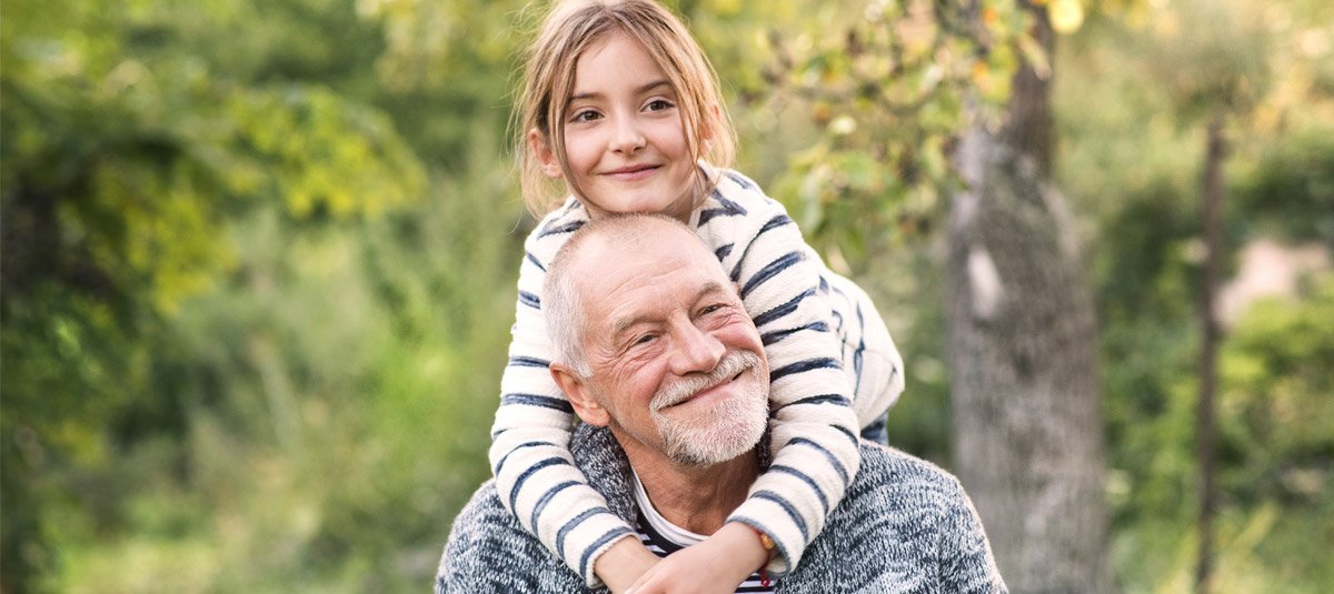 Grandfather Carrying His Grandaughter On His Shoulders