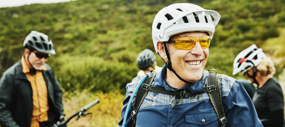 Portrait of smiling senior man hanging out with friends before early morning mountain bike ride